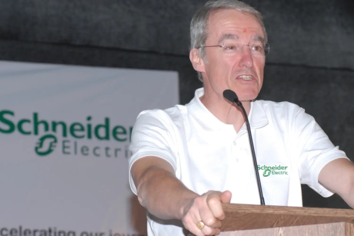 Man and woman speaking on stage at night with blue lighting